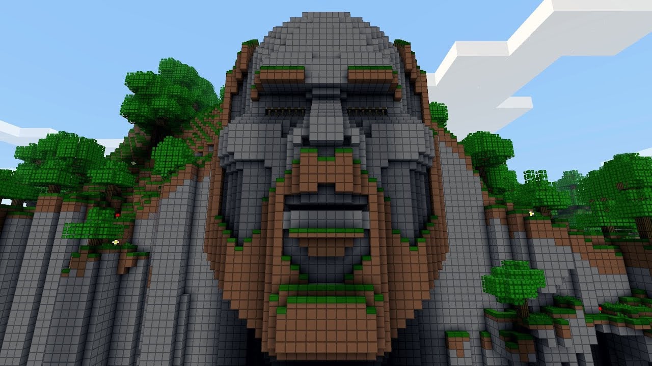 A statue of Minecraft creator Notch's head made of stone and dirt on a cliffside